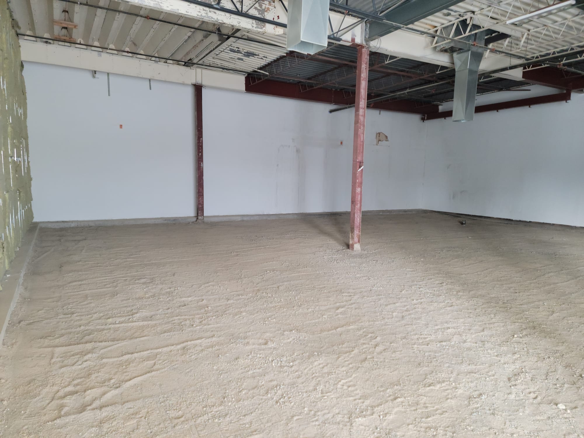 Empty commercial shell with exposed structure and ductwork